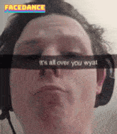 a man wearing headphones has a snap that says " it 's all over you wyat " on it