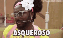 a man wearing glasses and a flower in his hair is sitting on a couch and saying asqueroso .