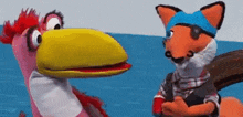 a fox and a pink bird are standing next to each other in the water .
