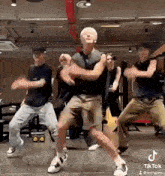 a group of men are dancing together in a room .
