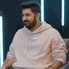 a man with a beard is wearing a white sweatshirt