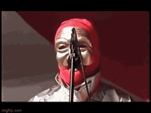 a man wearing a mask is singing into a microphone .