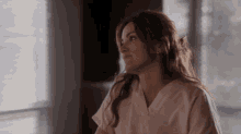 a woman in a pink scrub top looks to her left