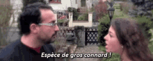 a man and a woman are talking to each other in front of a house and the woman is saying espèce de gros connard !