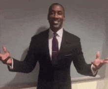 a man in a suit and tie with his arms outstretched .