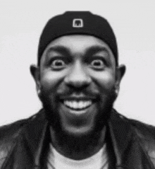 a black and white photo of a man with a beard wearing a hat