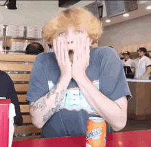 a can of sunkist sits on a table next to a surprised person