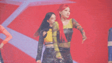 a group of women are dancing on a stage in front of a red background .