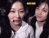 two girls are standing next to each other and one of them is wearing a white shirt