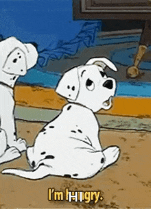 two dalmatian puppies are sitting next to each other on a carpet .