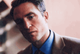 a man wearing a suit and tie looks at the camera