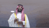 a man in a traditional arabian costume is smiling and holding his hands out