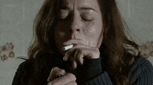 a woman is crying while smoking a cigarette with bbc on the bottom left