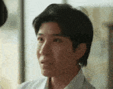 a close up of a young man 's face with a serious look on his face .
