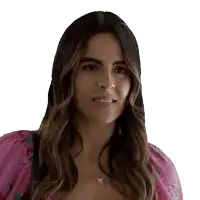 a woman wearing a pink top and a triangle necklace smiles