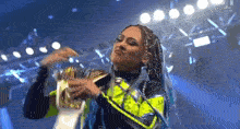 a woman with braids is holding a trophy in her hands .