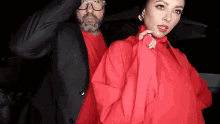 a man and a woman are standing next to each other in a photo booth .