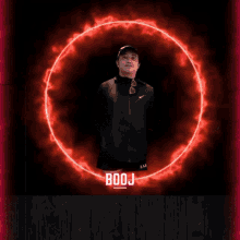 a man in a nike jacket stands in front of a red circle with the word booj on it