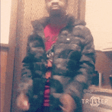 a man wearing a camouflage jacket and a red shirt