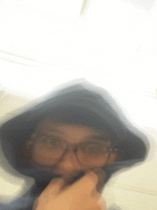 a blurry picture of a person wearing a hoodie and glasses