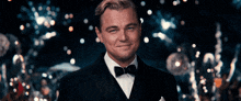 a man in a tuxedo is smiling in front of a crowd