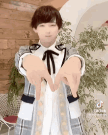 a young girl is making a heart with her hands .