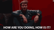 a man is sitting on a couch asking how are you doing