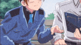 a man in a blue suit and tie holds the hand of another man in a white shirt