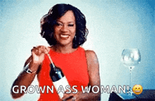 a woman in a red dress is holding a bottle of wine and saying grown ass woman !