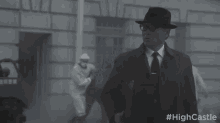 a man in a suit and tie is walking down a street .