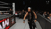 a woman in a wrestling ring with a sign that says raw on it