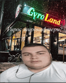 a picture of a man in front of a restaurant called gyro land