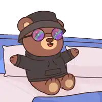 a teddy bear wearing a black hat and glasses is sitting on a bed