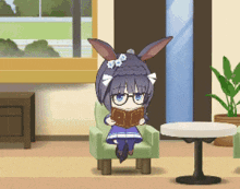 a little girl with bunny ears is sitting in a chair reading a book .