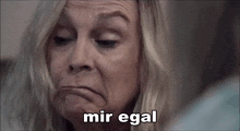 a close up of a woman making a face with the words mir egal written in the corner