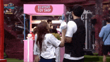 elvish 's toy shop is advertised on a pink sign