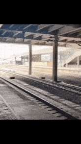 an empty train station with a few tracks and a few pillars