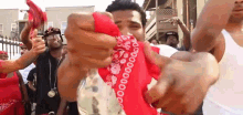 a man wearing a red bandana holds a bottle of money