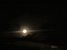 a full moon shines brightly in the dark sky