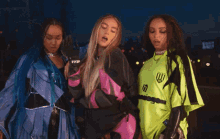 three women are standing next to each other and one of them is wearing a neon green shirt that says iu