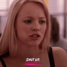a close up of a woman 's face with the words `` shut up , mean girls '' on the bottom .
