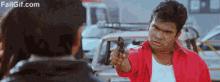 a man is pointing a gun at another man .