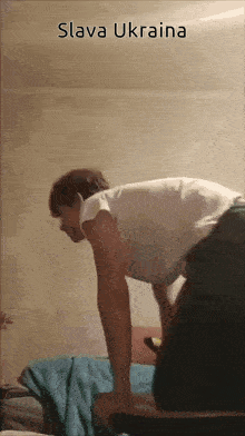 a man is doing push ups with the words slava ukraina above him