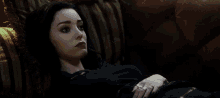 a woman is laying on a couch with a green light coming out of her mouth