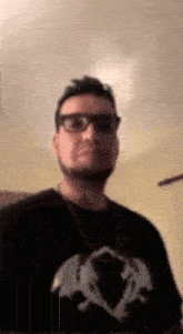 a man wearing glasses and a black shirt with a dragon on the front