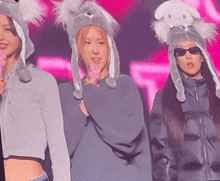 three women wearing bunny hats and sunglasses are standing next to each other