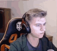 a young man is wearing headphones and sitting in a chair .