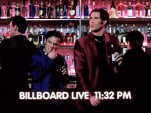 a man in a red suit stands in front of a bar with the words billboard live 11:32 pm on the bottom