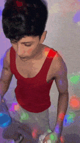 a man in a red tank top is standing in front of a colorful background ..