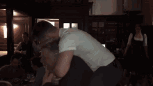 a man is carrying another man on his shoulders in a restaurant